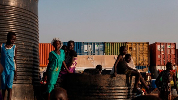 Internally displaced children sit on and around water tanks at Tomping camp in Juba